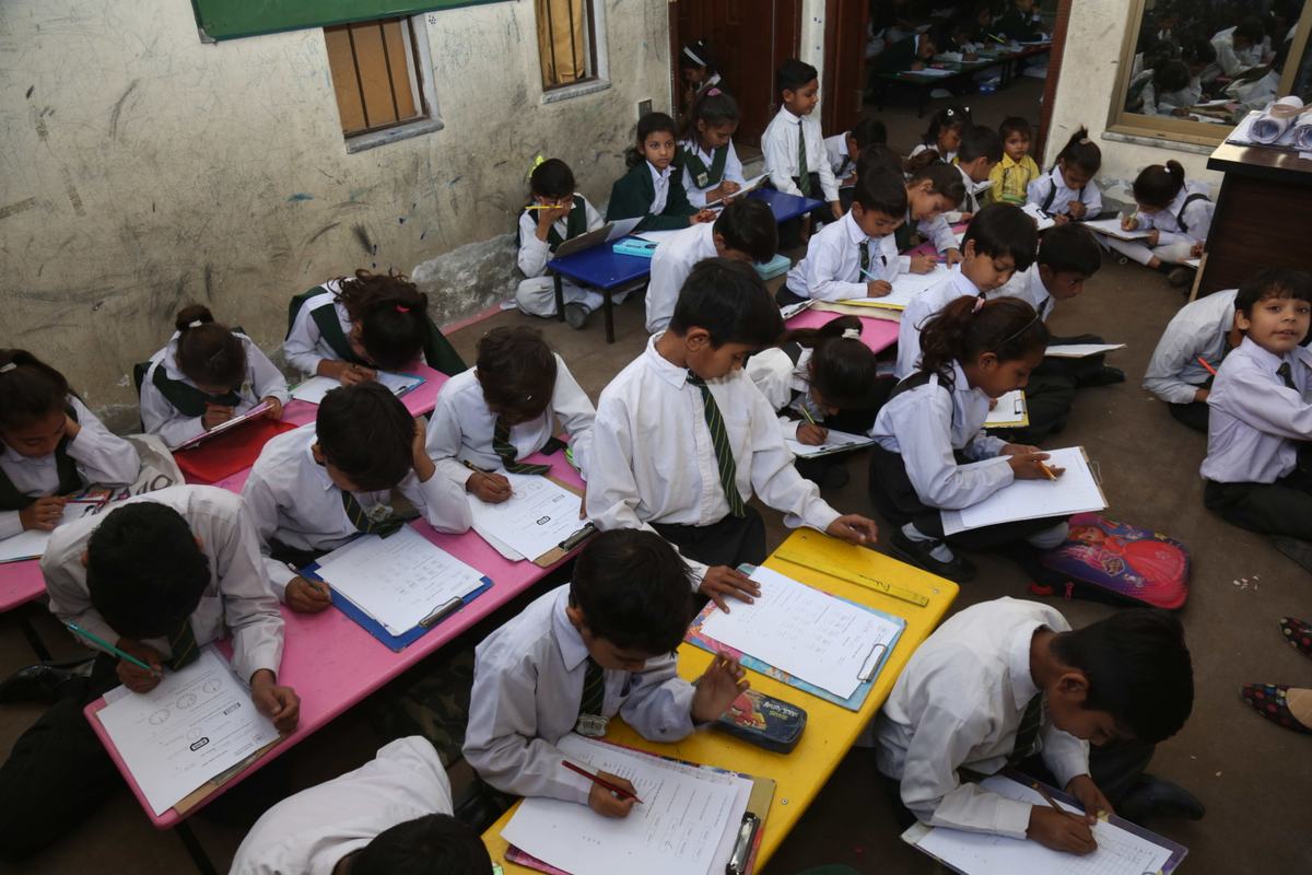 Children writing at colourful low desks