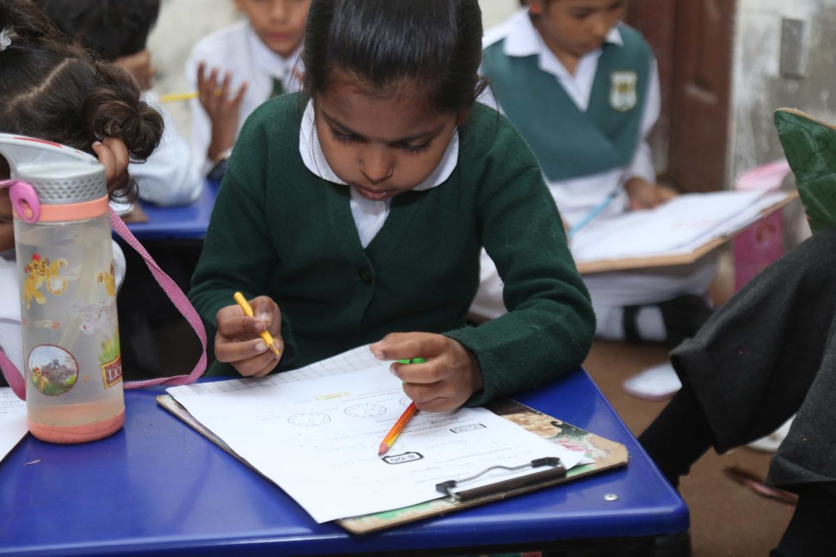 A young pupil writing in class